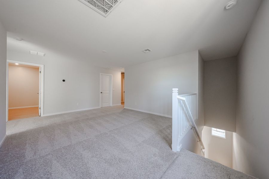 A long hallway with white doors.