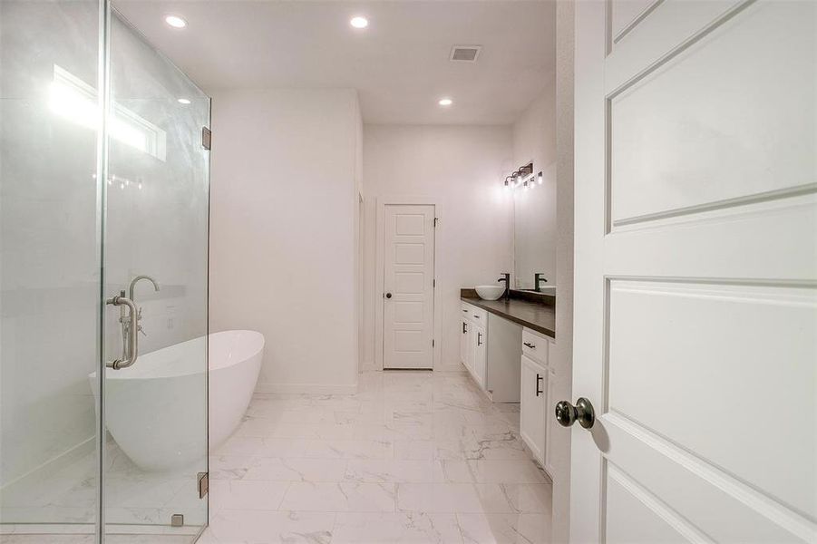 Bathroom featuring plus walk in shower and vanity