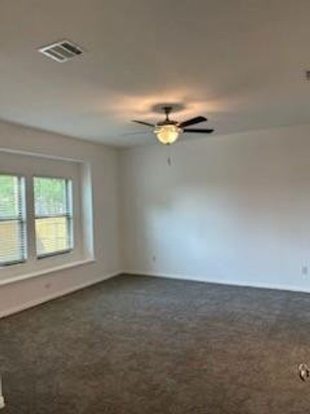 Primary bedroom with carpeted floors and ceiling fan