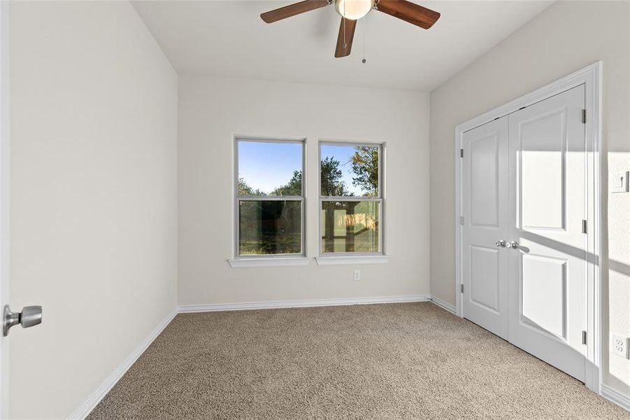 Unfurnished bedroom with light carpet, ceiling fan, and a closet