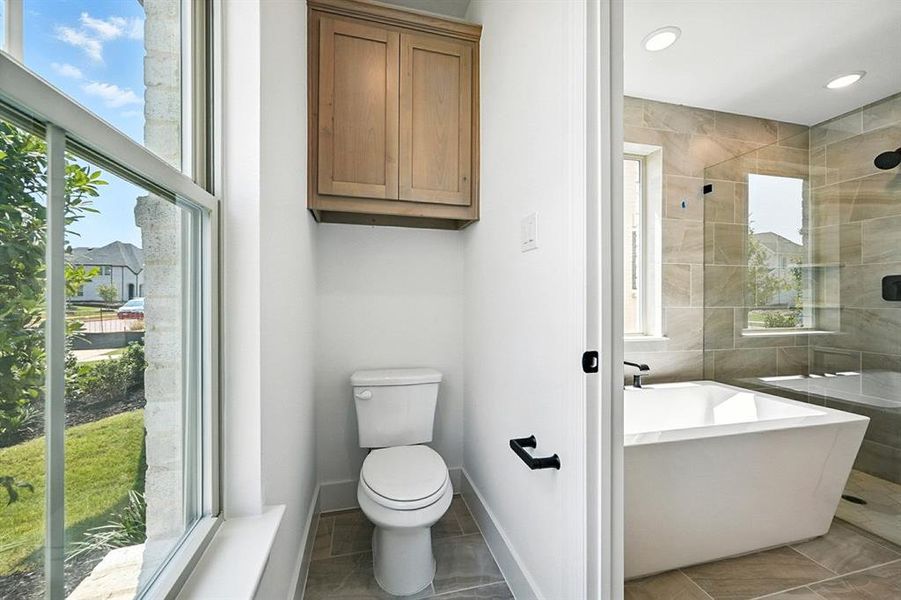Bathroom featuring a freestanding bath, a tile shower, light tile patterned floors, and recessed lighting Bathroom featuring a freestanding bath, a tile shower, light tile patterned floors, and recessed lighting