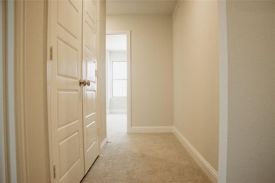 Hallway featuring light carpet