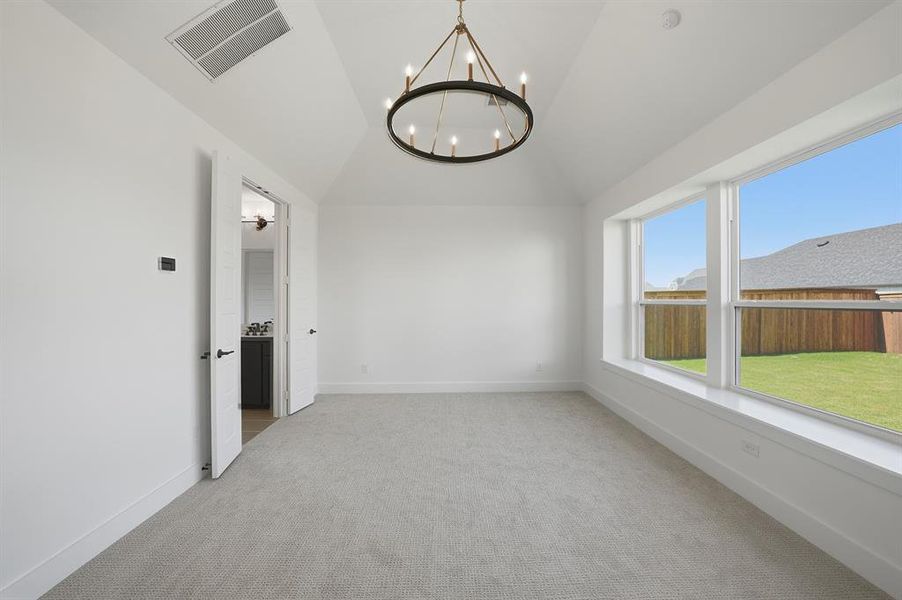 Unfurnished dining area with vaulted ceiling, light colored carpet, and a chandelier Unfurnished dining area with vaulted ceiling, light colored carpet, and a chandelier