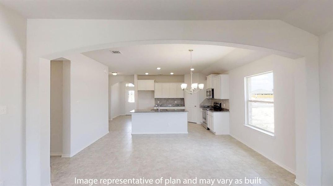 Kitchen featuring white cabinetry, tasteful backsplash, arched walkways, stainless steel appliances, and a chandelier Kitchen featuring white cabinetry, tasteful backsplash, arched walkways, stainless steel appliances, and a chandelier