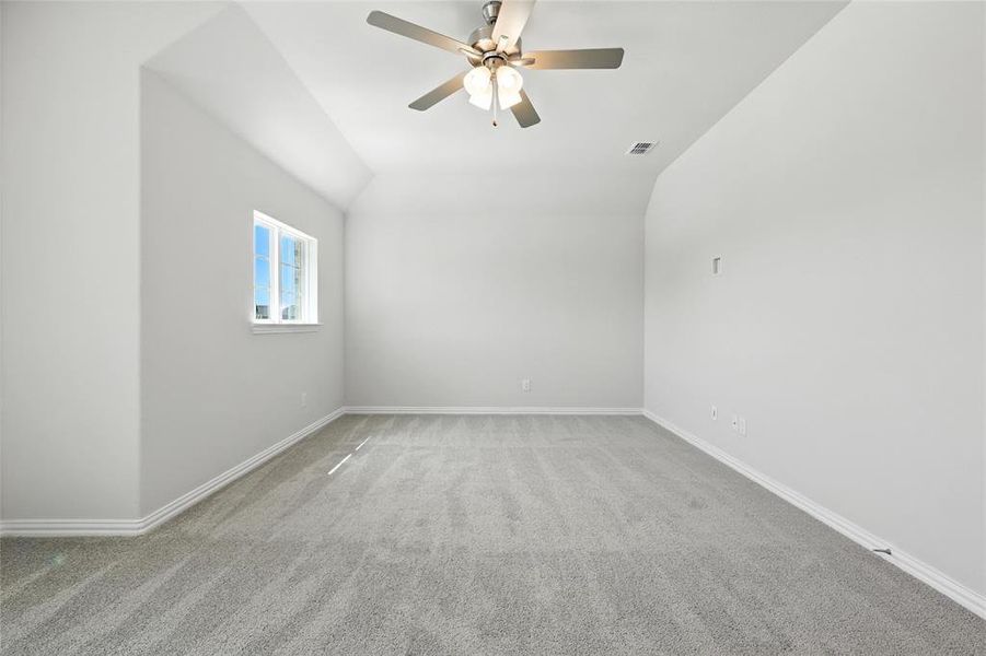 Unfurnished room with light colored carpet, a ceiling fan, and lofted ceiling