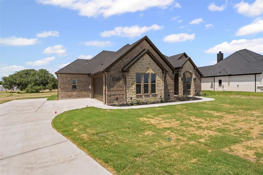 French provincial home featuring concrete driveway, a garage, a front yard, and brick siding French provincial home featuring concrete driveway, a garage, a front yard, and brick siding