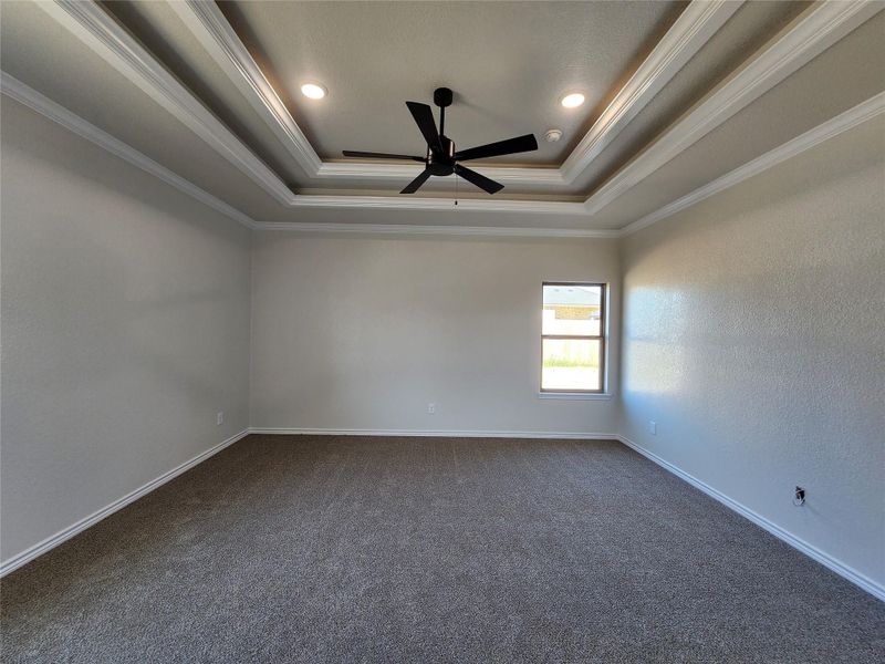 Spare room with dark carpet, crown molding, ceiling fan, a textured wall, and recessed lighting