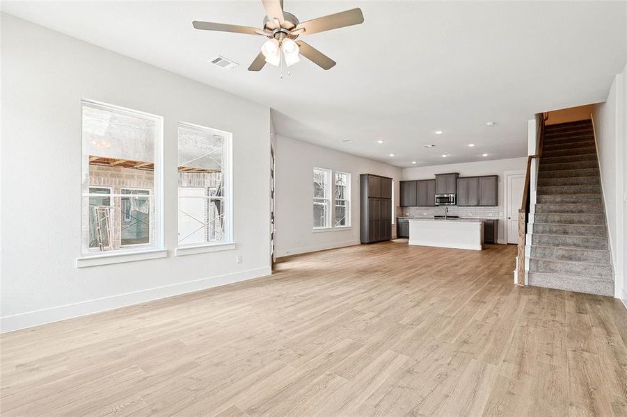 Unfurnished living room with light hardwood / wood-style flooring and ceiling fan