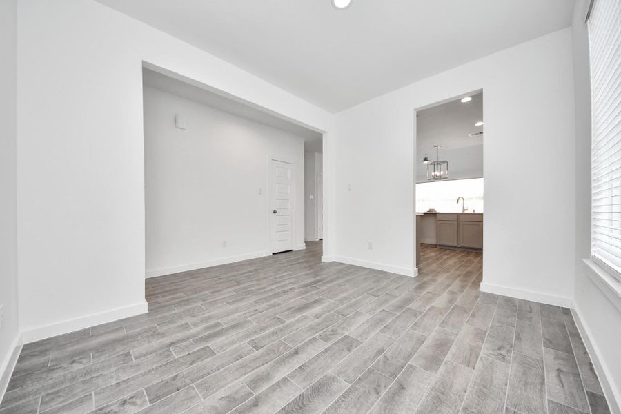 Make memories gathered around the table with your family and friends! This spacious dining room features elegant flooring, custom paint, and adjacent to family room and kitchen for open concept feel. Sample photo of completed home with similar floor plan. Actual colors and selections may vary.