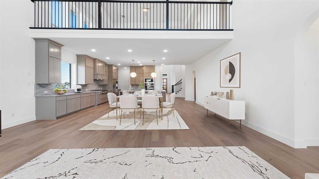 Dining room featuring a towering ceiling and light hardwood / wood-style flooring