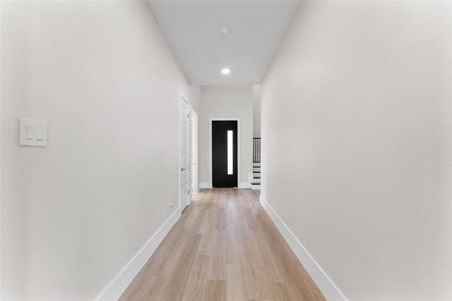 Corridor featuring light wood-type flooring and recessed lighting Corridor featuring light wood-type flooring and recessed lighting