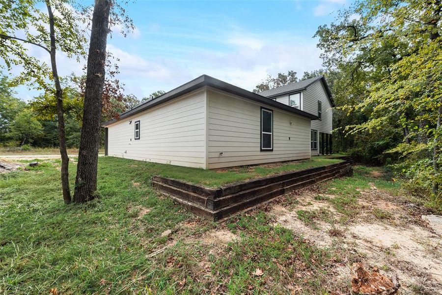 View of property exterior with a lawn