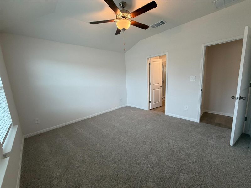 Unfurnished bedroom featuring lofted ceiling, ceiling fan, and carpet floors