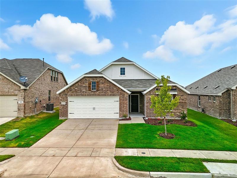 View of front facade featuring concrete driveway, a front yard, a garage, and brick siding View of front facade featuring concrete driveway, a front yard, a garage, and brick siding