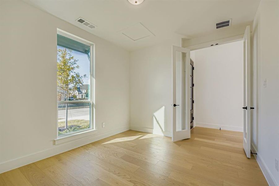 Unfurnished room with light wood-style floors and attic access Unfurnished room with light wood-style floors and attic access