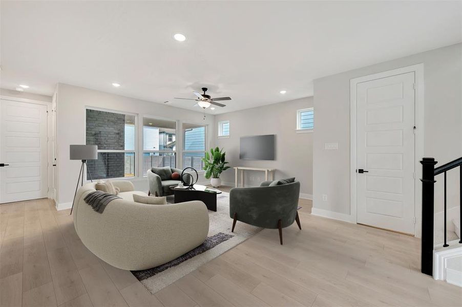 Living room with light wood-type flooring, healthy amount of natural light, a ceiling fan, and recessed lighting