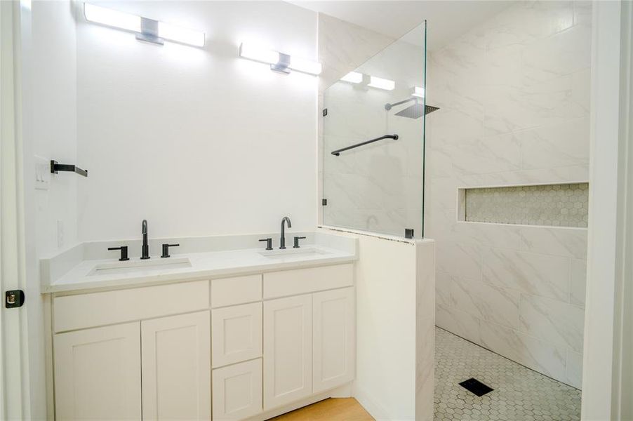 Bathroom with tiled shower and vanity