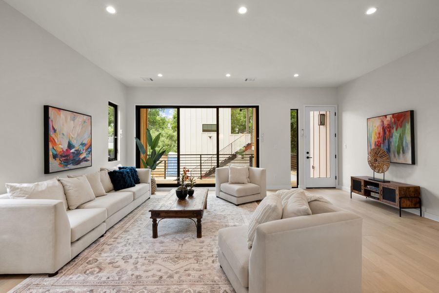 A luminous living room, framed by wide sliding glass doors, offers elegant light wood flooring. A luminous living room, framed by wide sliding glass doors, offers elegant light wood flooring.