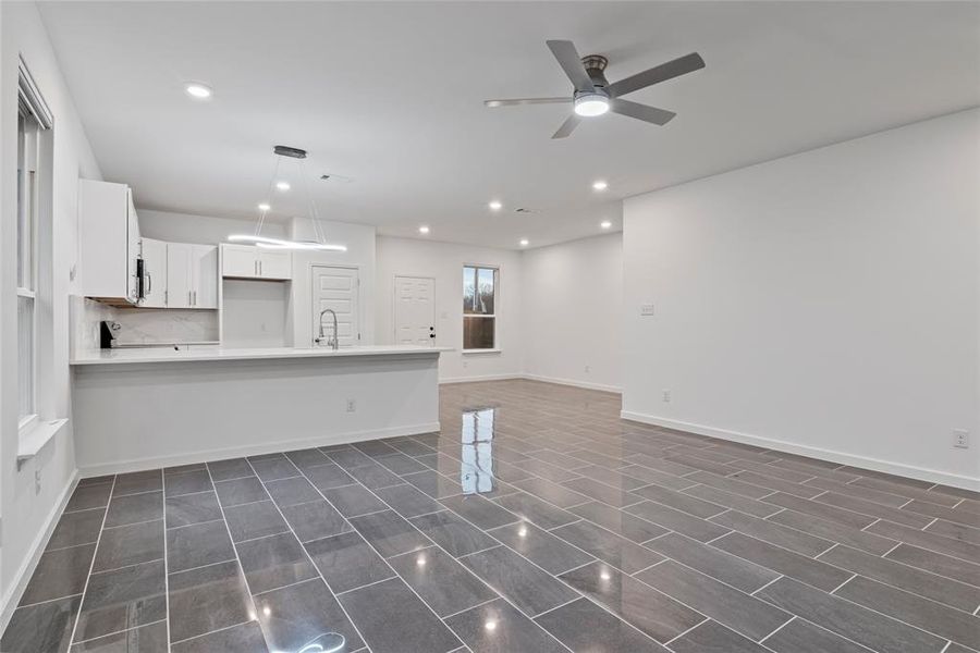 Kitchen featuring sink, white cabinetry, kitchen peninsula, pendant lighting, and ceiling fan