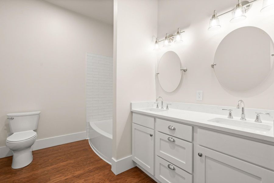 Double vanities and a deep soaking tub create a luxurious primary bathroom retreat. Double vanities and a deep soaking tub create a luxurious primary bathroom retreat.