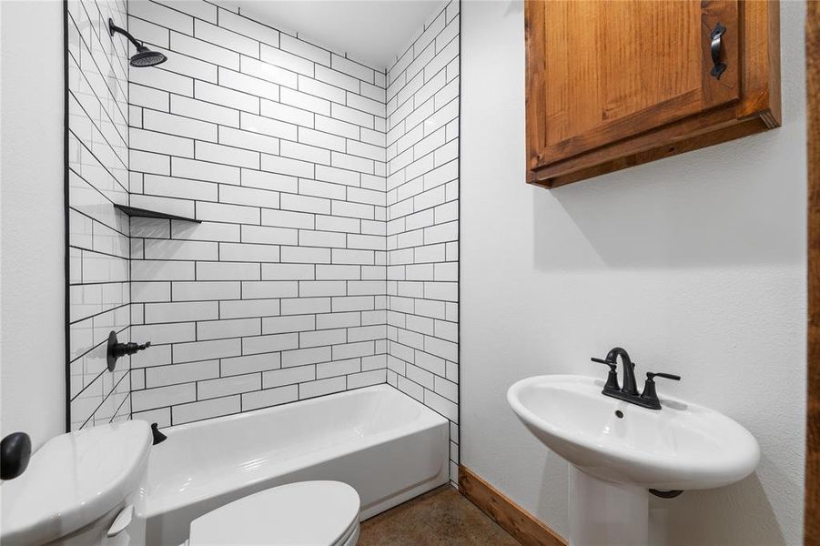 Full bathroom featuring shower / bathing tub combination, baseboards, toilet, and a sink Full bathroom featuring shower / bathing tub combination, baseboards, toilet, and a sink