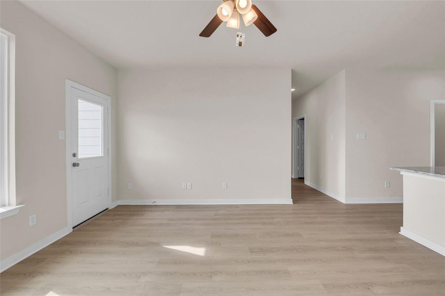 Unfurnished living room with light wood-type flooring and ceiling fan