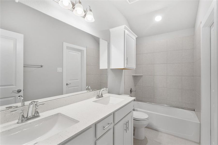 The secondary bath features double sinks, offering convenience and efficiency for busy mornings. With ample counter space and elegant fixtures, this bathroom combines functionality with style.