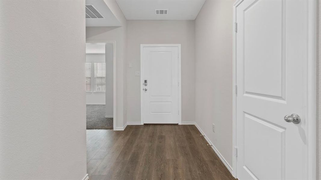 Corridor featuring dark wood-style flooring and baseboards