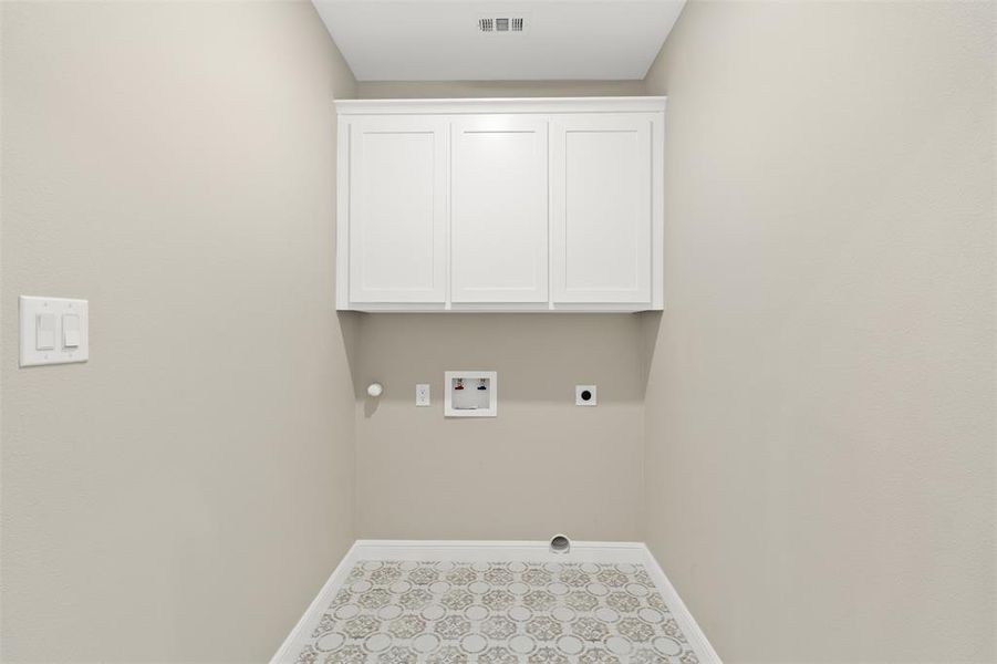 Washroom with hookup for an electric dryer, hookup for a washing machine, and cabinet space