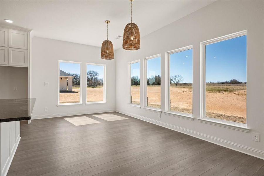 Unfurnished dining area featuring dark wood-style flooring, recessed lighting, and baseboards