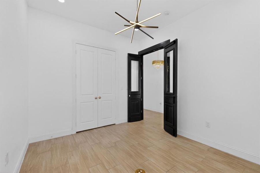 Contemporary sputnik-style chandelier illuminating a room with light wood-finish flooring, white baseboards, and white walls Contemporary sputnik-style chandelier illuminating a room with light wood-finish flooring, white baseboards, and white walls