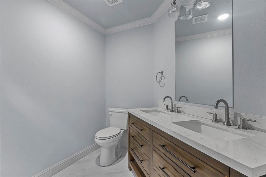 Bathroom with toilet, crown molding, and vanity