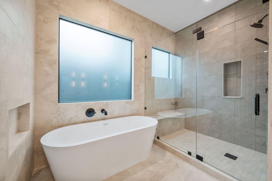 Full bathroom featuring a freestanding tub, a shower stall, and tile walls