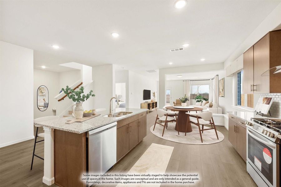 Open kitchen with island, wood cabinets, granite countertops, and stainless appliances opening to dining area