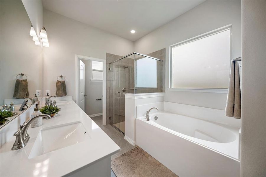 Bathroom with a bath, a shower stall, double vanity, and light tile patterned floors Bathroom with a bath, a shower stall, double vanity, and light tile patterned floors