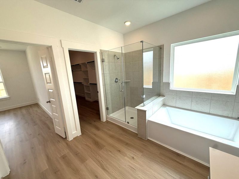 A spacious walk-in shower, elegant tilework, and premium fixtures offers a refreshing start to the day, while the soaking tub provides the perfect place to unwind in the evenings.
