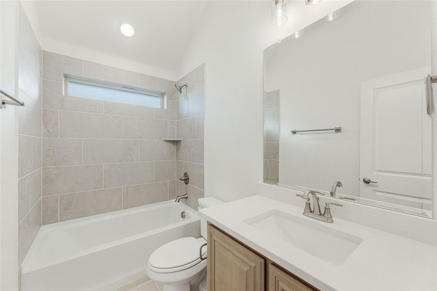 Bathroom with tiled tub-shower combo, single vanity with white countertop, and large mirror