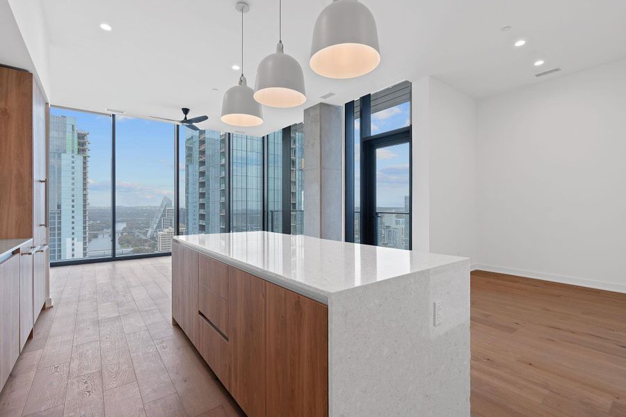 Kitchen featuring modern cabinets, expansive windows, light wood-style floors, decorative light fixtures, and recessed lighting