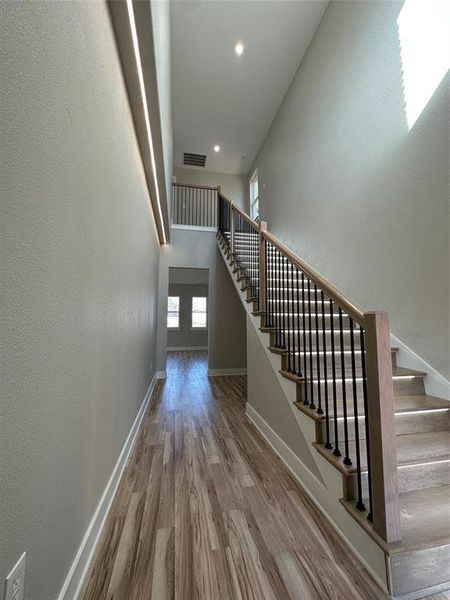 Staircase featuring a high ceiling and hardwood / wood-style floors