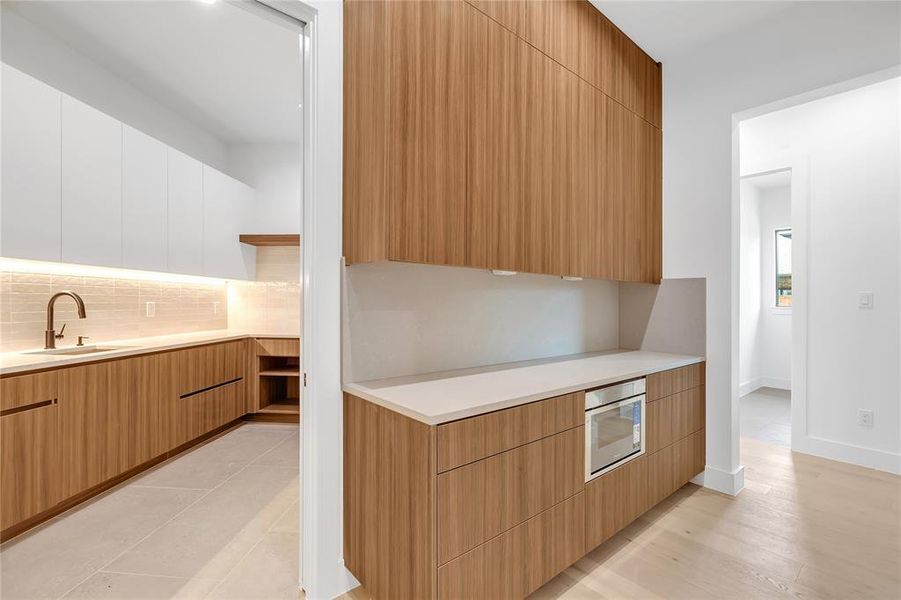 Kitchen with modern cabinets, backsplash, and light countertops Kitchen with modern cabinets, backsplash, and light countertops