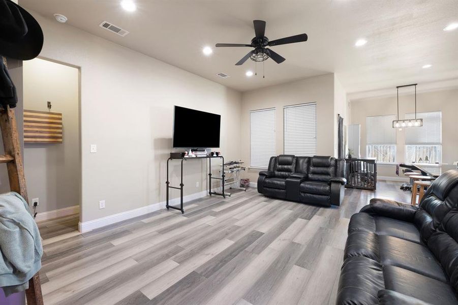 Living room with ceiling fan and light hardwood / wood-style flooring