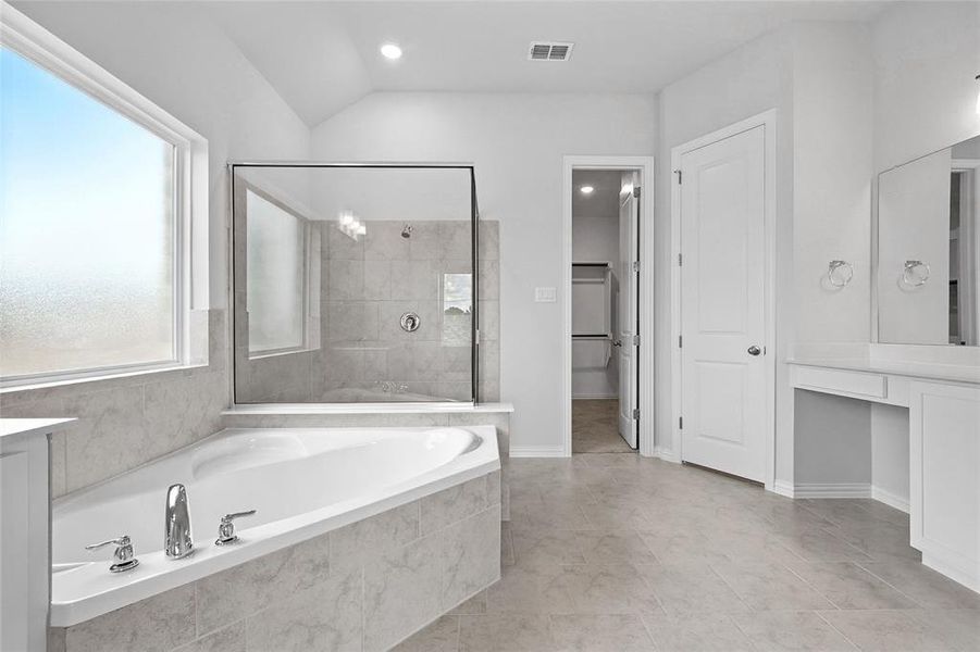 Full bath featuring a bath, vanity, tiled shower, vaulted ceiling, and a closet Full bath featuring a bath, vanity, tiled shower, vaulted ceiling, and a closet