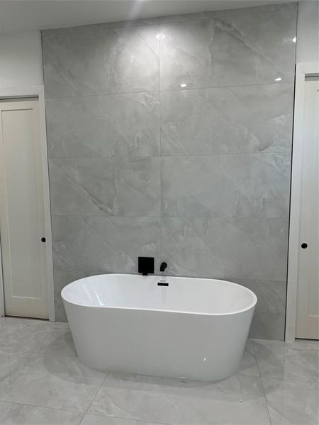 Bathroom with a bathtub and tile walls