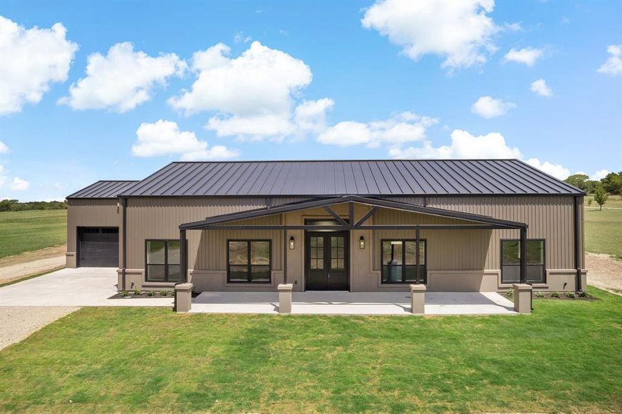 Front of house with a porch, a garage, and a lawn