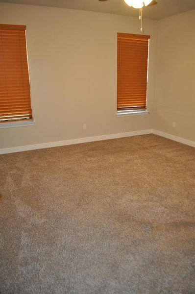 Empty room featuring ceiling fan and carpet