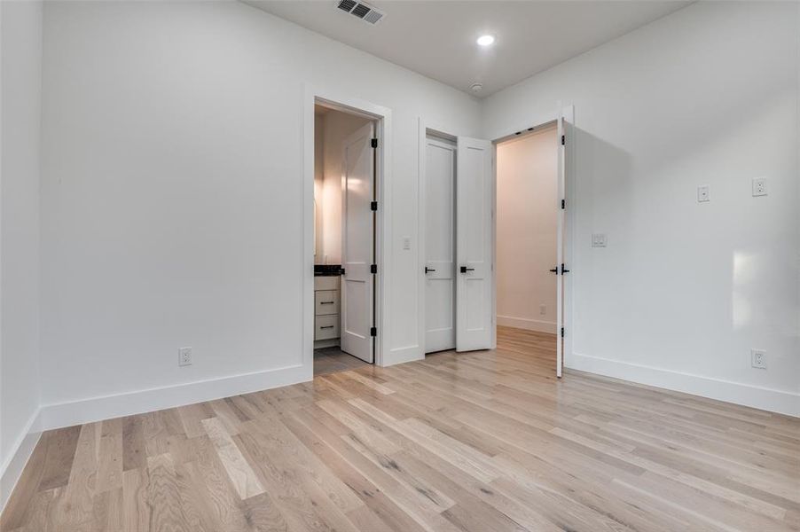 Unfurnished bedroom featuring light wood-style floors, recessed lighting, and ensuite bath Unfurnished bedroom featuring light wood-style floors, recessed lighting, and ensuite bath