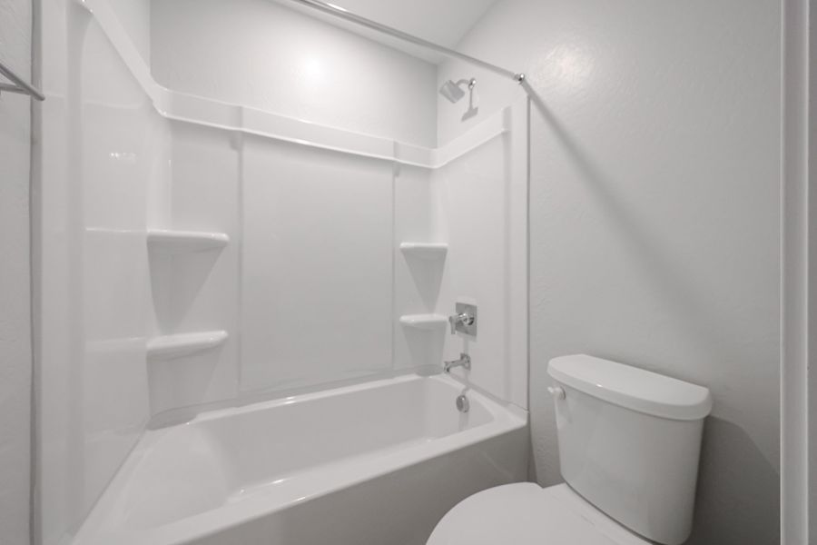 A bathroom with a toilet and bathtub.