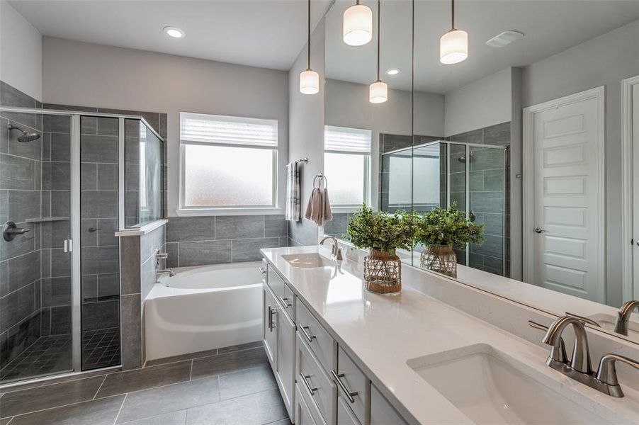 Bathroom featuring tile patterned floors, independent shower and bath, and double sink vanity