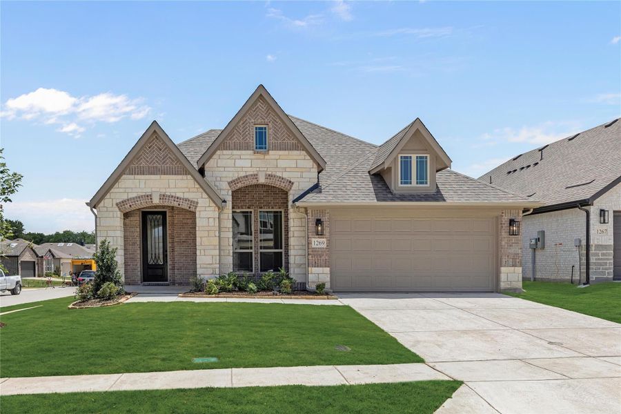 Single-story home with brick and stone exterior, arched entry, two-car garage, and green front lawn Single-story home with brick and stone exterior, arched entry, two-car garage, and green front lawn