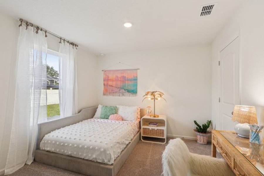 A bedroom with a bed and a table.